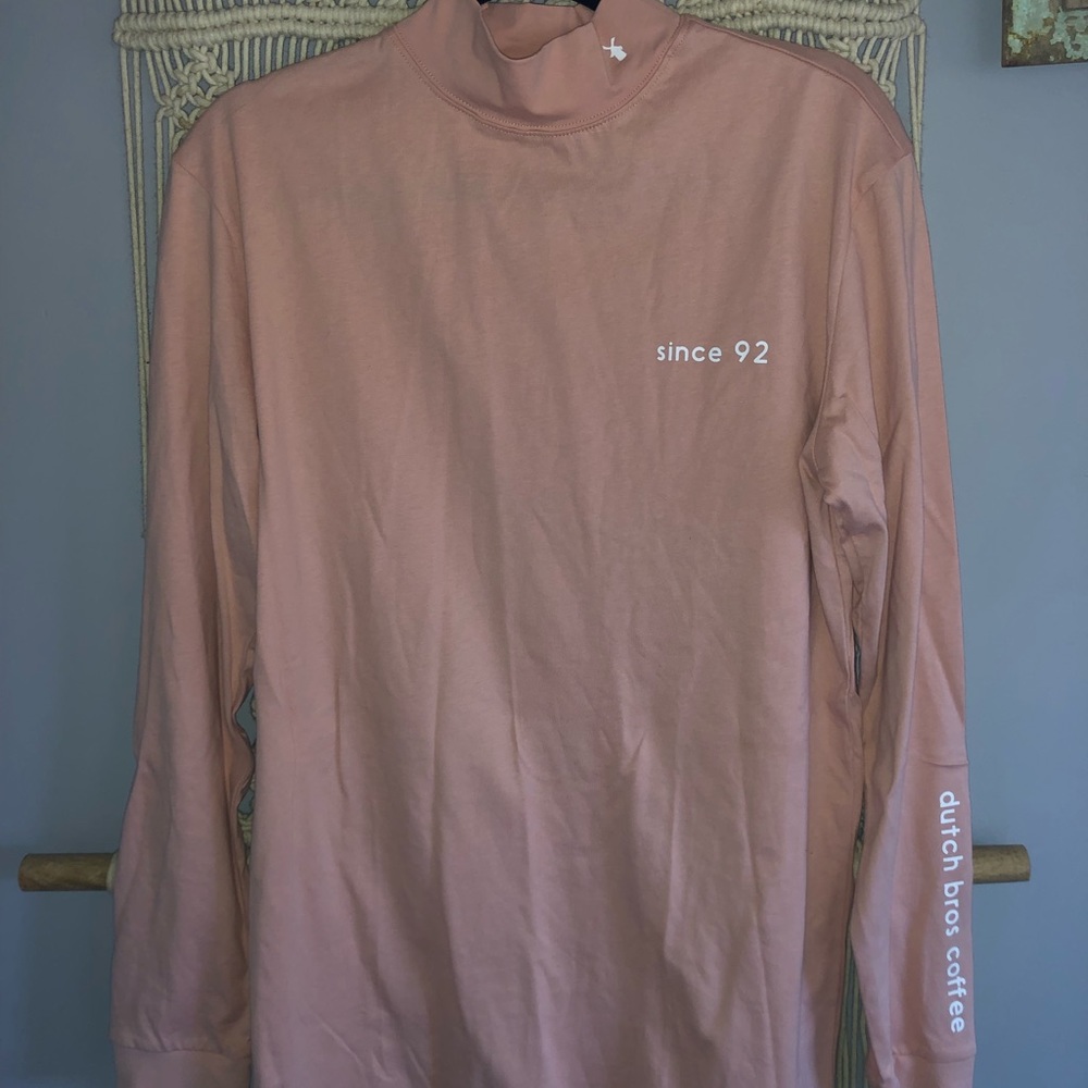 Long sleeve, turtle neck, peachy pink color in person. Dutch wear.